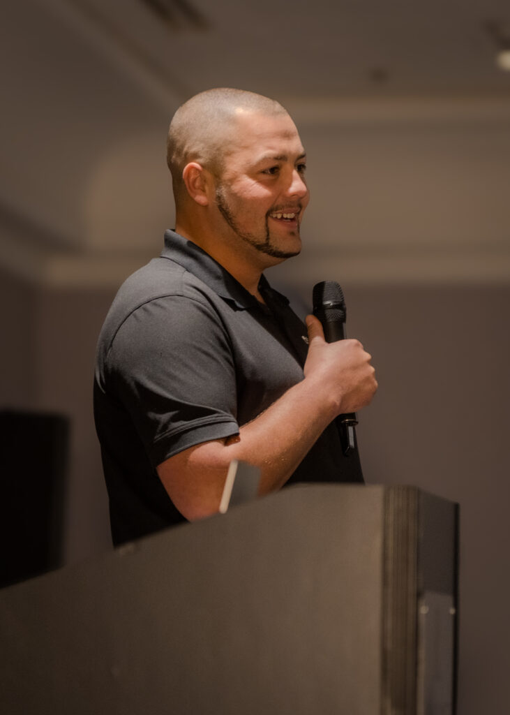 Confident male speaker smiling while receiving feedback during a talk