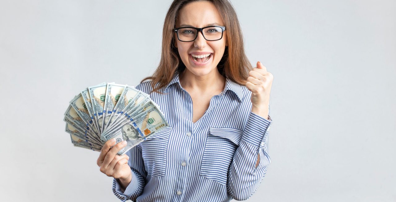Portrait,Of,A,Cheerful,Young,Businesswoman,Holding,Money,Banknotes,And